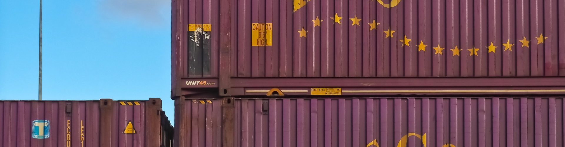 Bild av MichaelGaida från Pixabay föreställande tre stycken vinröda containrar med bokstäverna ECS i gult.